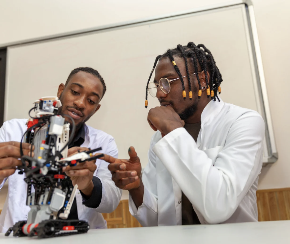 Jeunes adultes observant un projet technologique dans un contexte d'apprentissage